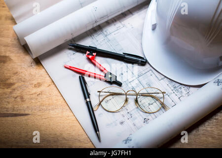 construction concept image helmet rolled blueprints on wooden boards in retro style. Stock Photo