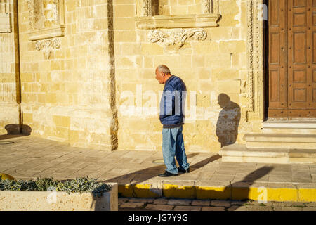 Gallipoli, Italy - March 3, 2017: Elderly man walking through sunny street of Italy Stock Photo