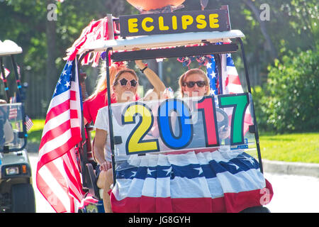 Sullivan's Island, South Carolina, USA. 4th July, 2017. A family rides a golf cart celebrating the upcoming solar eclipse during the annual Sullivan's Island Independence Day parade July 4, 2017 in Sullivan's Island, South Carolina. The solar eclipse will be visible from the Charleston area for the longest period in the continental USA before moving over the Atlantic Ocean. Credit: Planetpix/Alamy Live News Stock Photo
