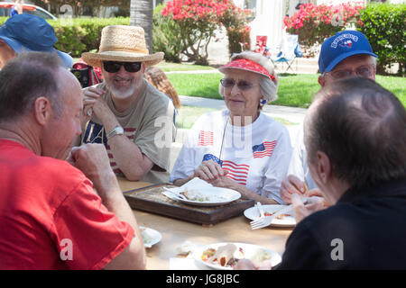 Long Beach, USA. 04th July, 2017. Neighbors visit around a picnic table in the middle of the street at the Bluff Heights 4th of July Block Party, Long Beach, CA Credit: Kayte Deioma/Alamy Live News Stock Photo