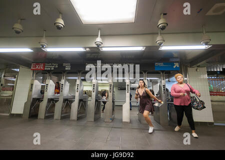 Passengers swipe through the turnstiles in the newly restored South Ferry subway station in New York on re-opening day Tuesday, June 27, 2017. The restored station was closed after catastrophic damage by Superstorm Sandy with an estimated 15 million gallons of water flooding the terminal which cost $545 million and was only open three years. The $340 million in repairs were finished today nearly five years after Superstorm Sandy. In the interim the Number One train used the quirky old South Ferry loop which only accommodated the first five cars of a ten car train.  (© Richard B. Levine)