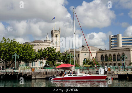 Marina with red sailboat and Parliament Buildings in background Bridgetown Barbados. Stock Photo