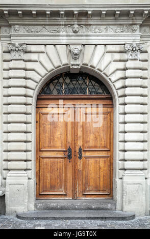Old wooden door in gray stone wall, background texture. Luzern, Switzerland Stock Photo