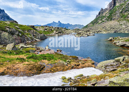 Mountain lake in hanging valley and melting snow. Ergaki Ridge. Western Sayan. Southern Siberia. Russia Stock Photo