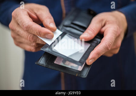 Bank card, business card, wallet, businessman holds in his hands and put the card in your wallet Stock Photo