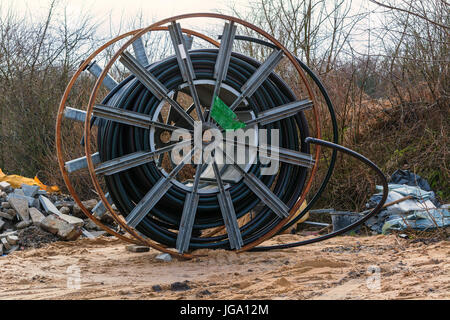 Steel roller with fiber optic cables for the installation of data cables on a construction site. Stock Photo