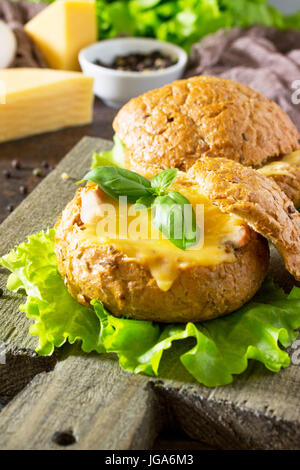 Delicious baked burger from bacon, eggs, cheese served with fresh lettuce leaves. Ingredients for cooking scrambled eggs. Stock Photo