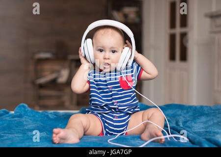 Funny baby boy wearing white headphones Stock Photo