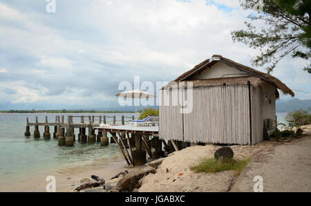 A wooden house on the sand beach with blue sea background. Stock Photo