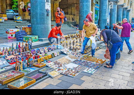 TBILISI, GEORGIA - JUNE 2, 2016: People look for some interesting souvenirs in stall of street market in Rustaveli Avenue, on June 2 in Tbilisi. Stock Photo