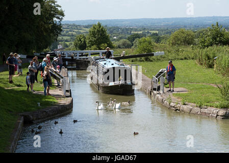 Canalboat passing through a lock at the top of Cael Hill a flight of locks on the Kennet & Avon Canal in Devizes Wiltshire England UK Stock Photo