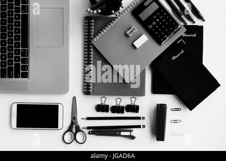 Empty notepad and modern smart phone mockup on white office desk surrounded  with office supplies. Top view. Flat lay Stock Photo - Alamy