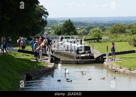 Canalboat passing through a lock at the top of Cael Hill a flight of locks on the Kennet & Avon Canal in Devizes Wiltshire England UK Stock Photo