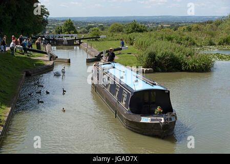 Canalboat passing through a lock at the top of Cael Hill a flight of locks on the Kennet & Avon Canal in Devizes Wiltshire England UK Stock Photo