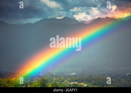 Beautiful bright rainbow in the sky after the heavy rain. Stock Photo