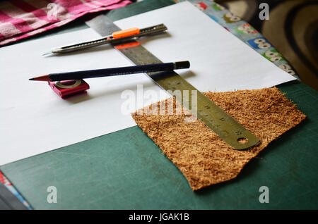Leather craft tools or equipment for made handcrafted genuine leather pocket for keep or winder wrapped earphone cable handmade leather local thai sty Stock Photo