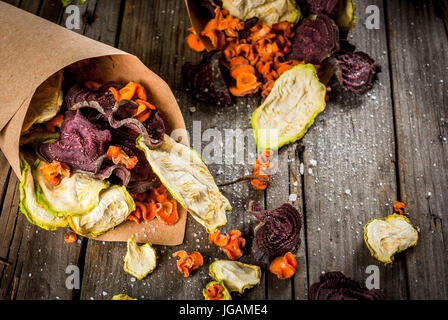 Organic diet food. The vegan diet. Dried vegetables. Homemade chips from beets, carrots and zucchini. On old wooden rustic table, with fresh vegetable Stock Photo