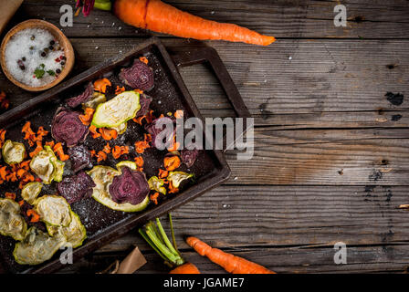 Organic diet food. The vegan diet. Dried vegetables. Homemade chips from beets, carrots and zucchini. On old wooden rustic table, with fresh vegetable Stock Photo