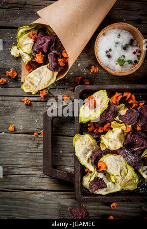 Organic diet food. The vegan diet. Dried vegetables. Homemade chips from beets, carrots and zucchini. On old wooden rustic table, with fresh vegetable Stock Photo