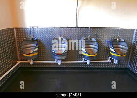 Gents urinals made from old recycled beer barrels Stock Photo