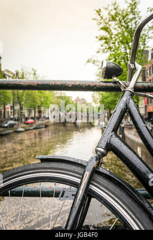 Black bike over canal in Amsterdam, The Netherlands Stock Photo
