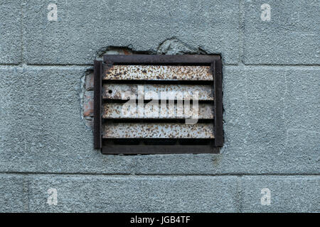 Photo texture of an old rusty ventilation grille on an old plastered wall painted gray Stock Photo