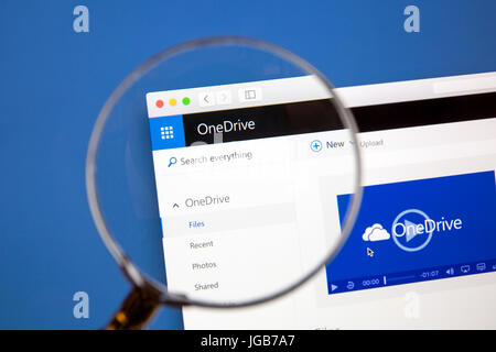 Microsoft OneDrive website under a magnifying glass. Microsoft OneDrive is a file hosting service. Stock Photo