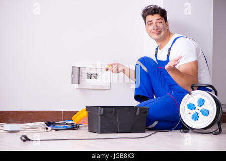 Funny Man doing electrical repairs at home Stock Photo
