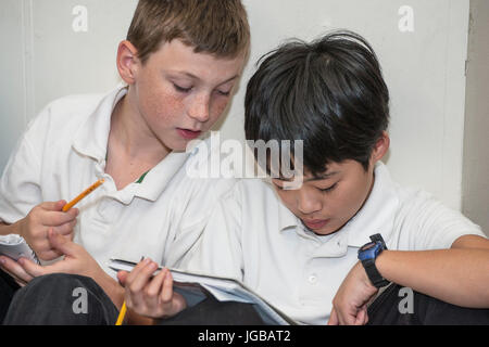 Two High School Students helping each other in class Stock Photo