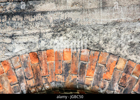 Close-up view of cracked old building brick wall with concrete on top, background concept Stock Photo