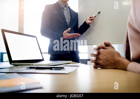 Businesswoman asking question during her colleagues presentation in bright office. Stock Photo