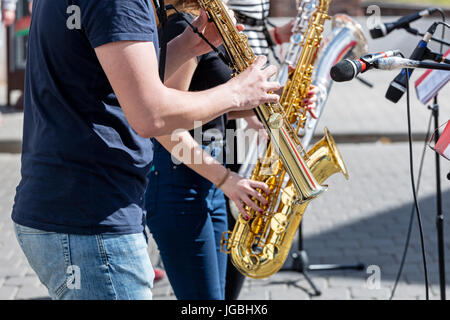 quartet of young musicians with saxophones performing during the music festival Stock Photo