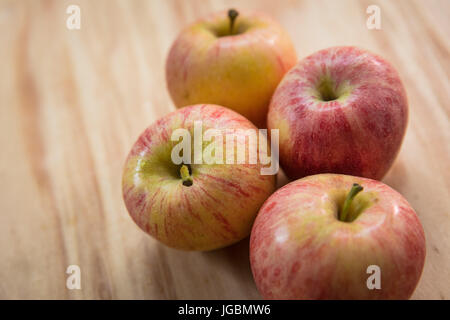 Four apples on a wooden surface.  Pink Lady variety Stock Photo