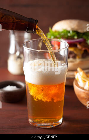 pouring india pale ale beer into pint glass and fast food Stock Photo