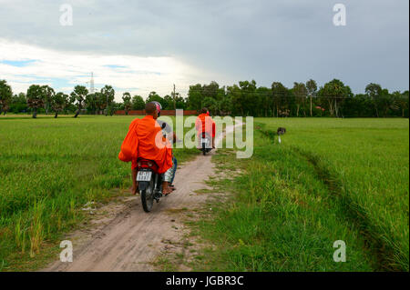 An Giang, Vietnam - Aug 7, 2016. Khmer monks riding scooter on countryside road in Mekong Delta, Vietnam. Khmer pagodas and villages surrounded by ric Stock Photo