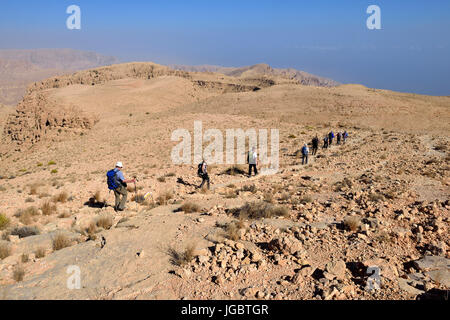 Tourists hiking above Wadi Tiwi, Al Hajar ash Sharqi mountains, Sharqiyah, Oman Stock Photo