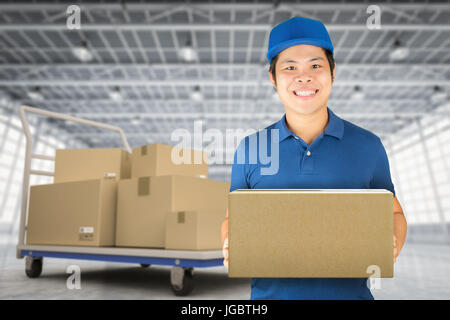 asian delivery man in distribution warehouse Stock Photo