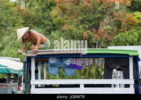 A man painting a boat in Borneo, Indonesia Stock Photo