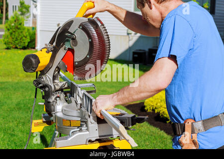Contractor Using Circular Saw Cutting New Crown Moulding for Renovation. Stock Photo