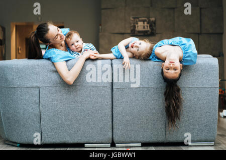 Mom, two daughters and a little son on the couch Stock Photo