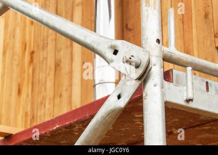 Detail of scaffolding joints at the building of a family house. Work on a building site of an ecological house Stock Photo
