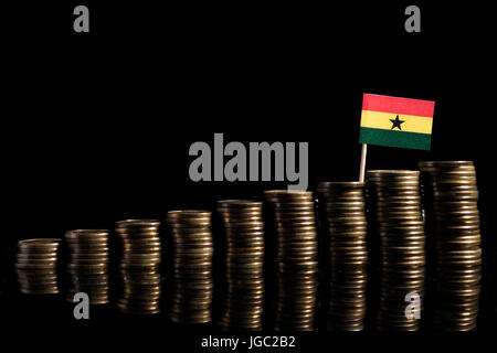 Ghanaian flag with lot of coins isolated on black background Stock Photo