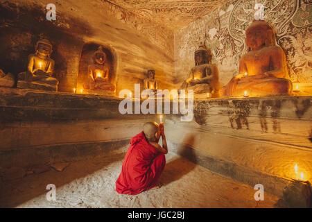 Monk praying with candle light at Po Win Taung / Hpowindaung cave - Monywa - Sagaing region - Northern Myanmar Stock Photo