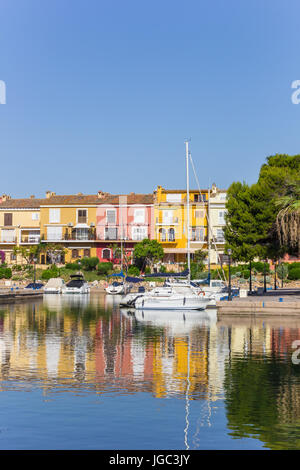 White sailing ship and colorful houses in Port Saplaya, Valencia, Spain Stock Photo