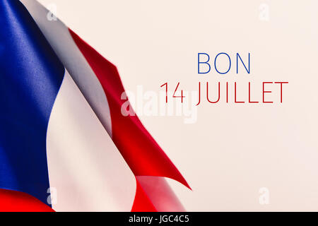 some french flags and the text text bon 14 juillet, happy 14 july, the national day of France written in French, against an off-white background Stock Photo