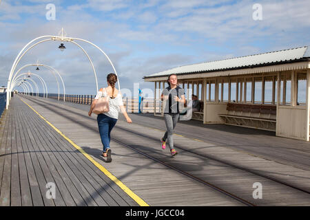 Southport, Merseyside.  UK Weather. 5th May, 2017.  Bright sunny start to the day. Sunshine in the resort at low tide as joggers and walkers take exercise on Southport’s Pier.  The landmark is a great public space for visitors, tourists and residents of the seaside town, to enjoy the  views across the Irish Sea. Credit; MediaWorldImages/AlamyLiveNews Stock Photo