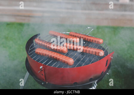 side view of cooking process of hot dog sausages on grill Stock Photo