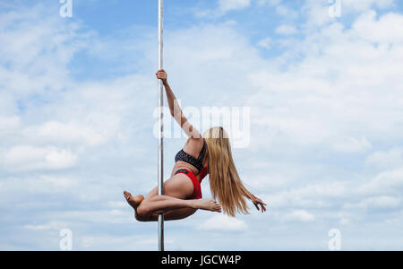 Woman pole dancing outdoors Stock Photo