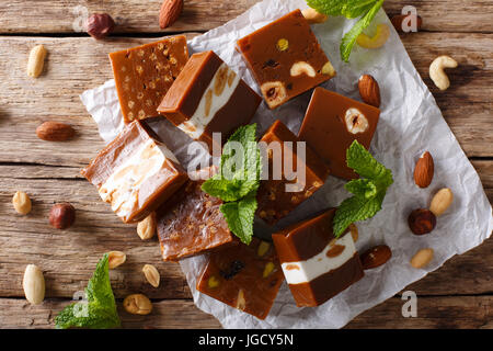 Caramelized toffee with various nuts close-up on the table. horizontal view from above Stock Photo