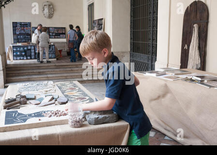 Kids learning how to make a stone mosaic Stock Photo